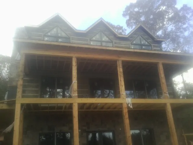 Dormers and porch framing on a large log home under construction — Roof Coating work by our crew in Rickreall