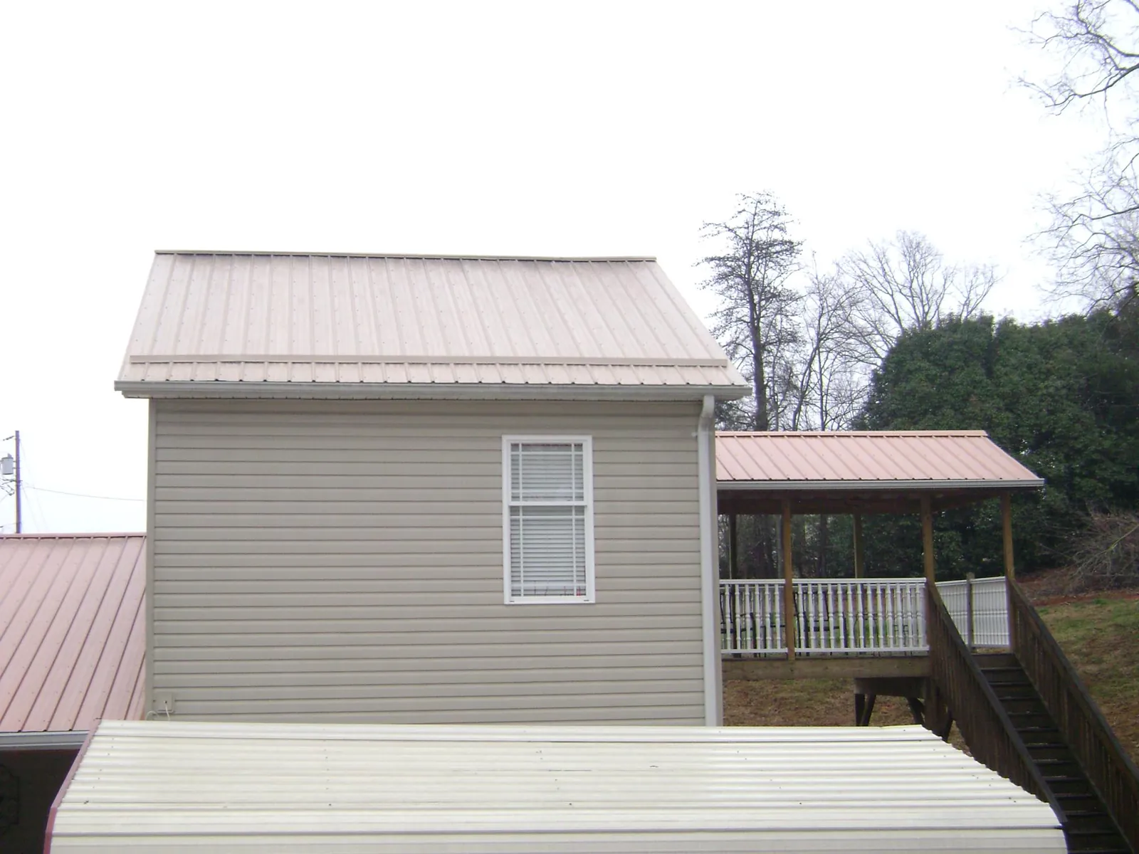 Tan metal roofs on a two story addition and attached porch, from a Roof Replacement job in Rickreall